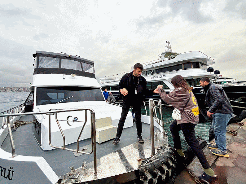 Omer Celik - Professional Tour Guide in Istanbul helping his guest board a boat