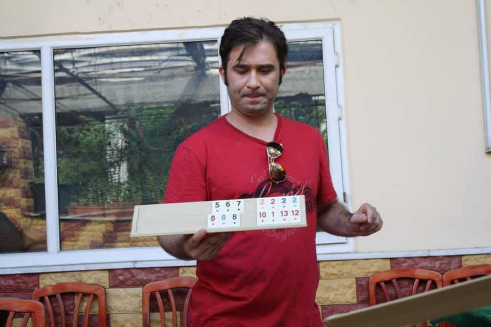 Murat Karatas teaching a Turkish board game during The Other Tour