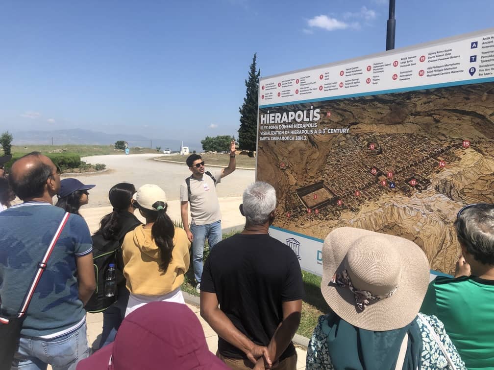 A local guide, Ahmet Üstündağ, is guiding a group into the ancient city of Hierapolis.