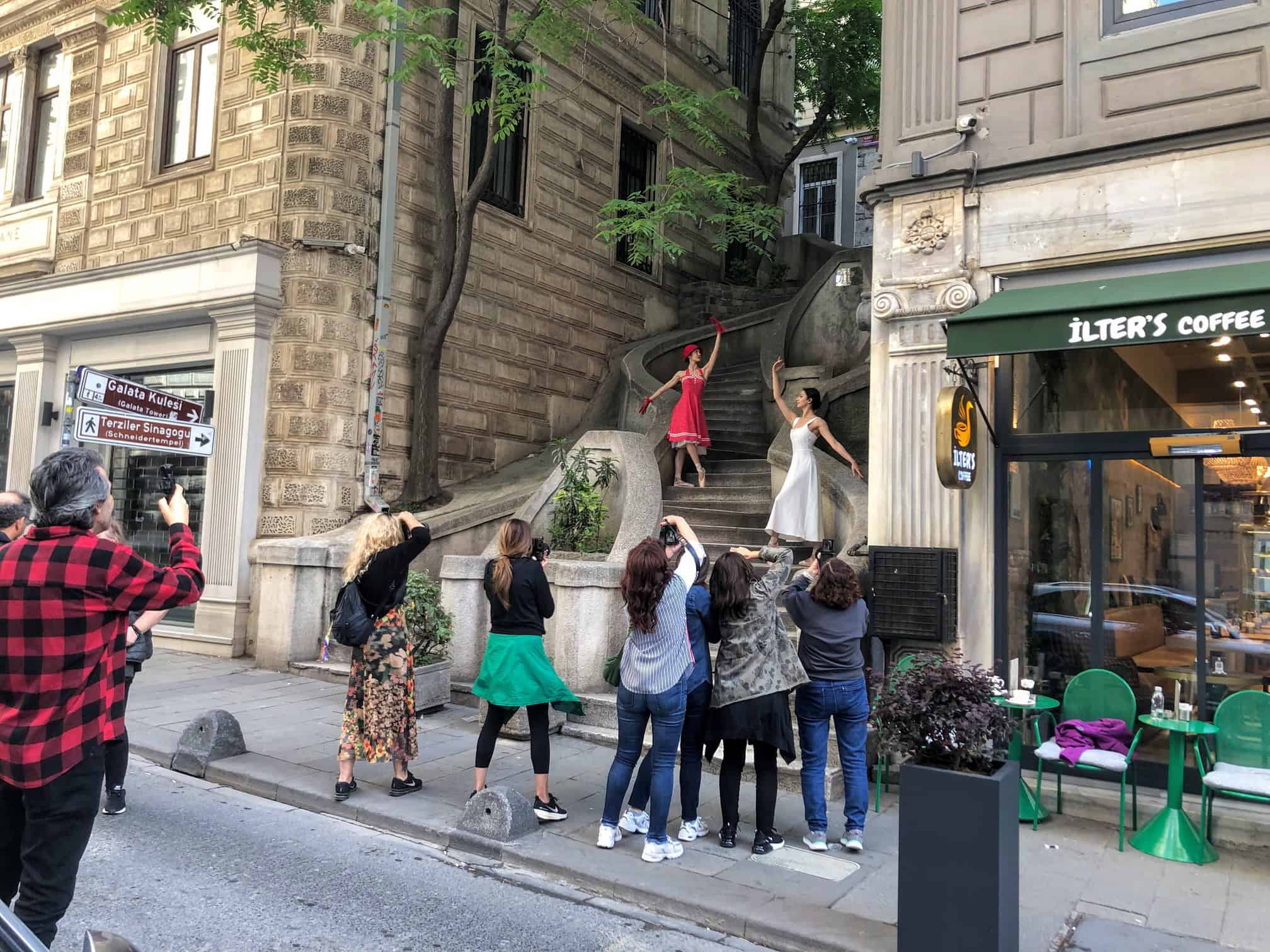 A guided group on a Karakoy street, one guest posing on a stairway for the others