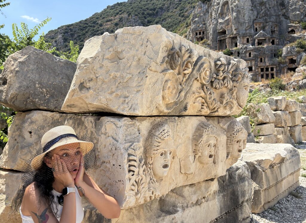A visitor reacts to the carved stone faces at Myra — the site rewards those who take time to look closely