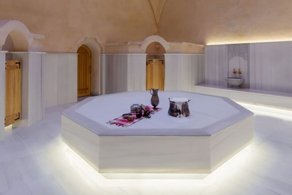 White marble göbek taşı with traditional bath accessories at Tarihi Çeşme Hamamı, Karaköy hamam