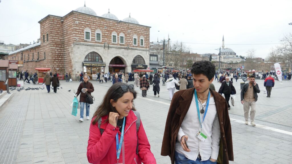 Tour guide and guest walking past the Egyptian Spice Bazaar entrance in Eminönü, Istanbul