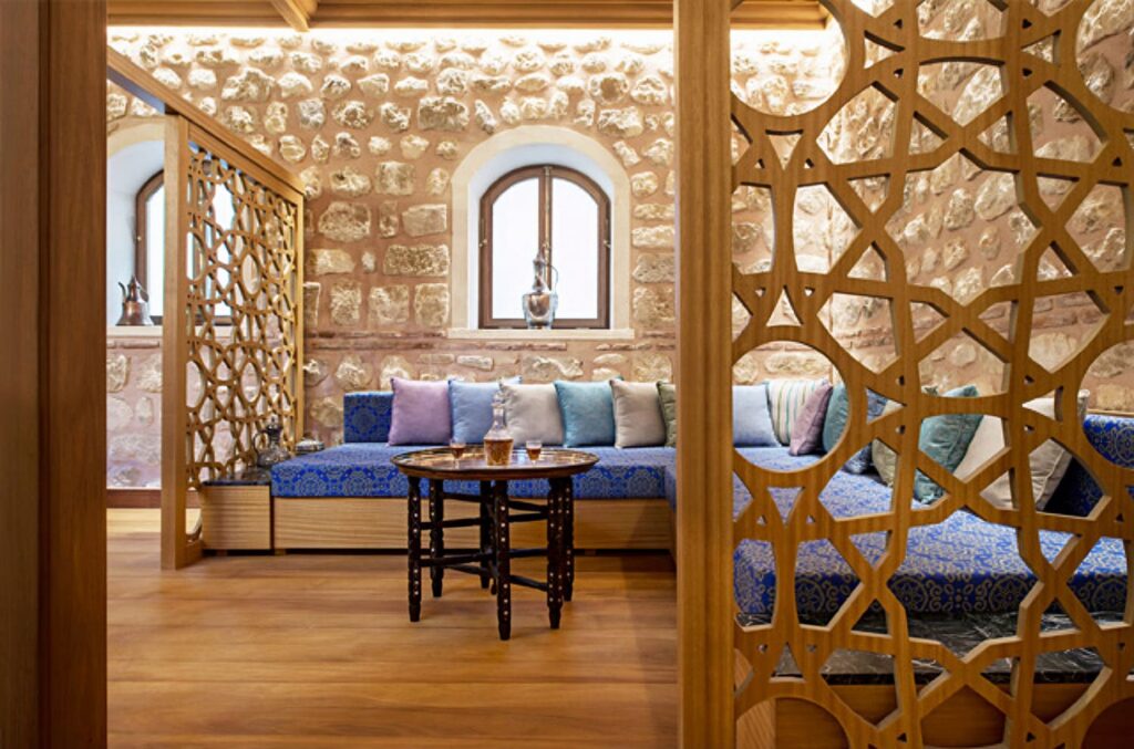 Ottoman-style relaxation room with carved wooden mashrabiya lattice and blue damask seating at Karaköy hamam