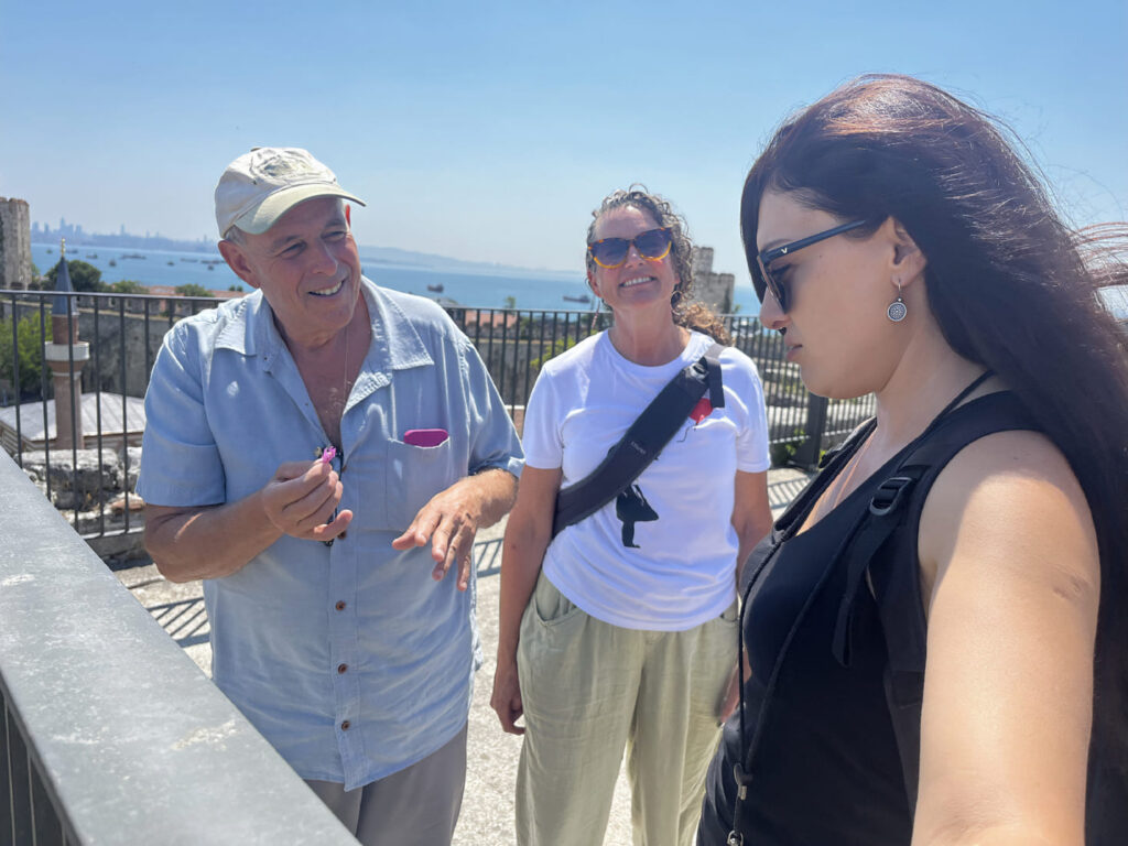 Tour guide serving fresh seasonal fruit to clients inside a private air-conditioned transfer vehicle with ambient lighting