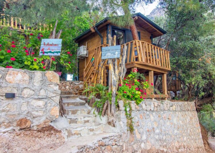 Wooden bungalow surrounded by greenery in Kabak Valley near Fethiye, Türkiye.