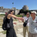 Tour guide gesturing to explain the layout of Yedikule Fortress to two visitors, with the main Ottoman round tower and crenellated walls behind them