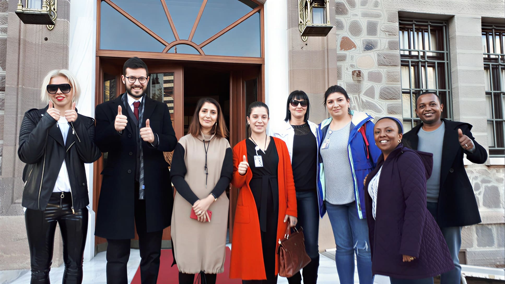 A group in formal dress outside a building in Istanbul with their guide