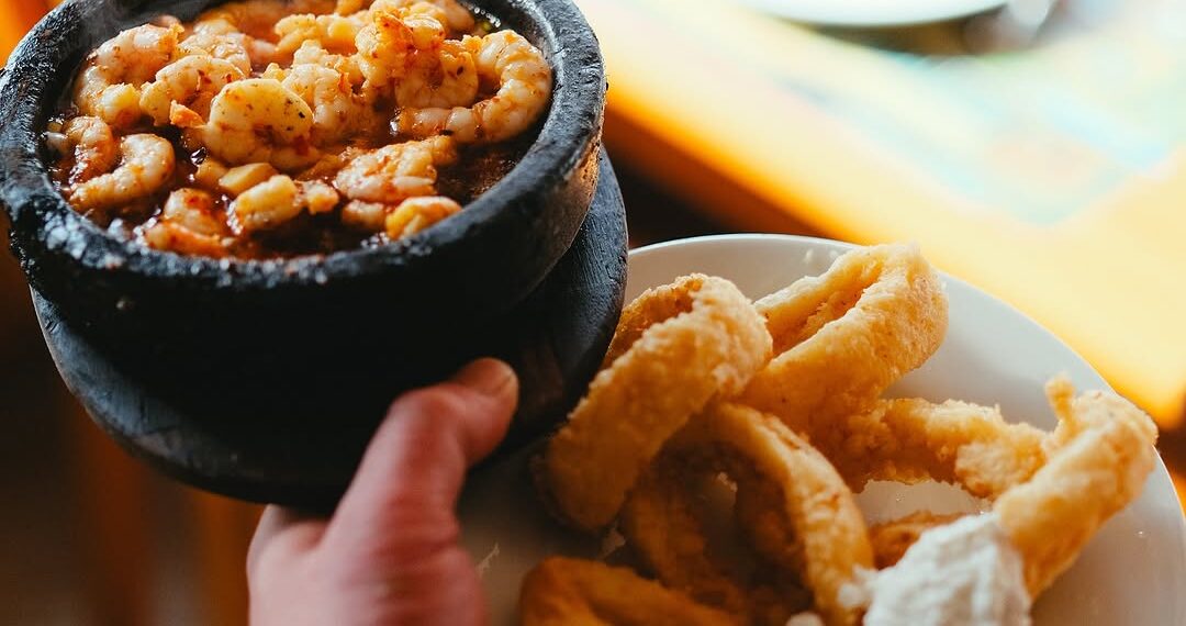 Grilled shrimp served in a hot stone bowl alongside crispy fried calamari at İsmet Baba Restaurant in Istanbul
