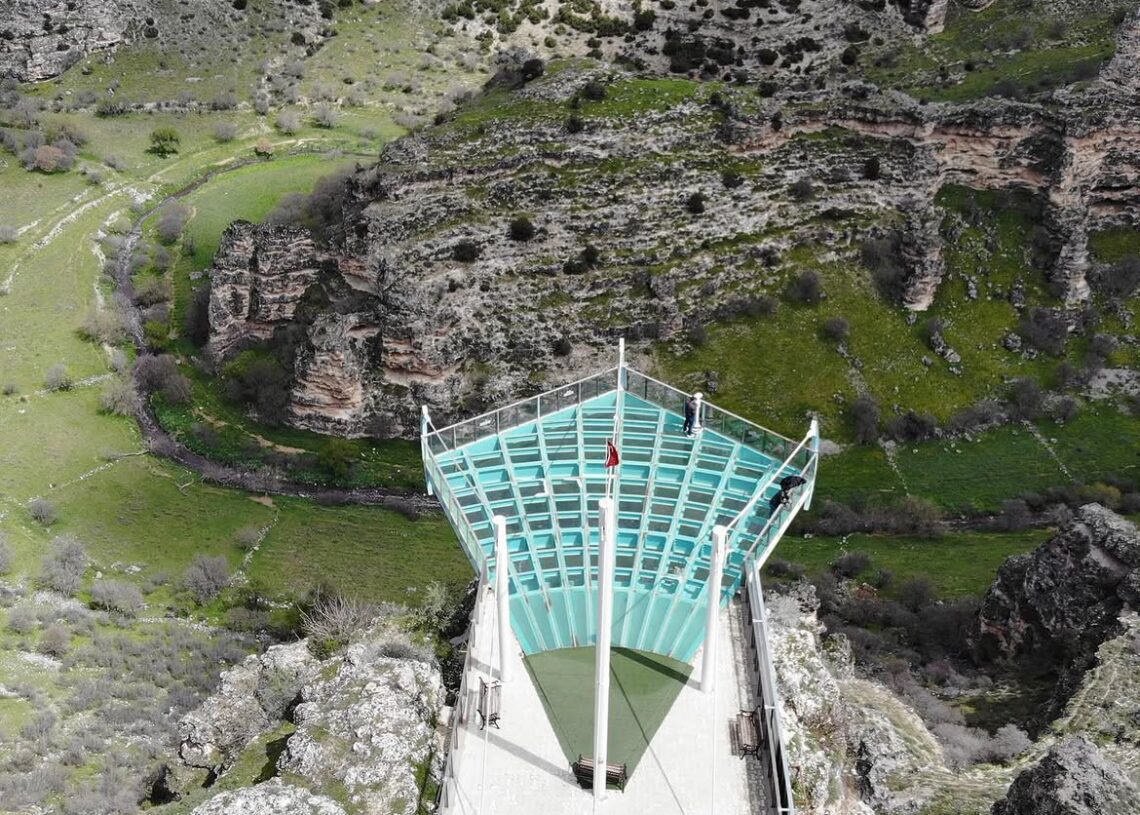 Visitors standing on the glass observation terrace overlooking Ulubey Canyon in Uşak, Turkey.