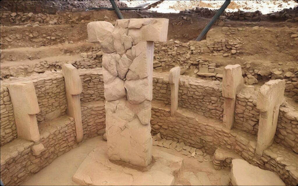 Reassembled central T-shaped pillar rising from a Göbekli Tepe enclosure ringed by smaller pillars
