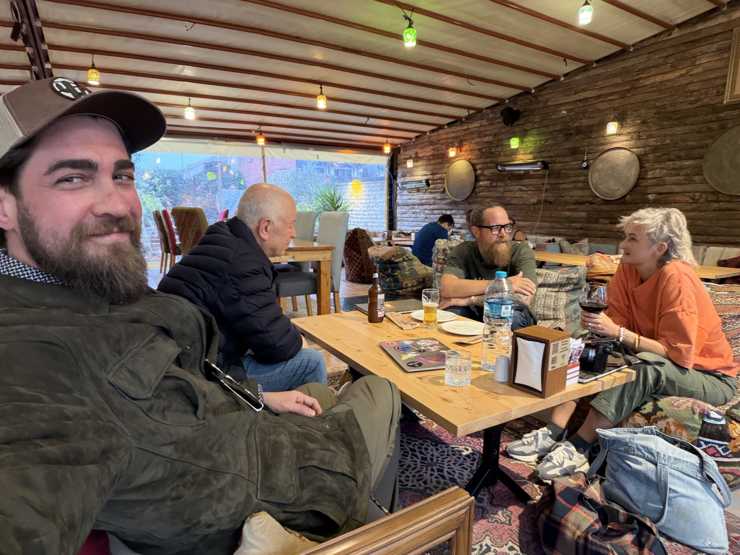 Fethi Karataş, Ahmet Diler, and guests sharing a meal and conversation after a guided Turkish kilim experience in Istanbul.