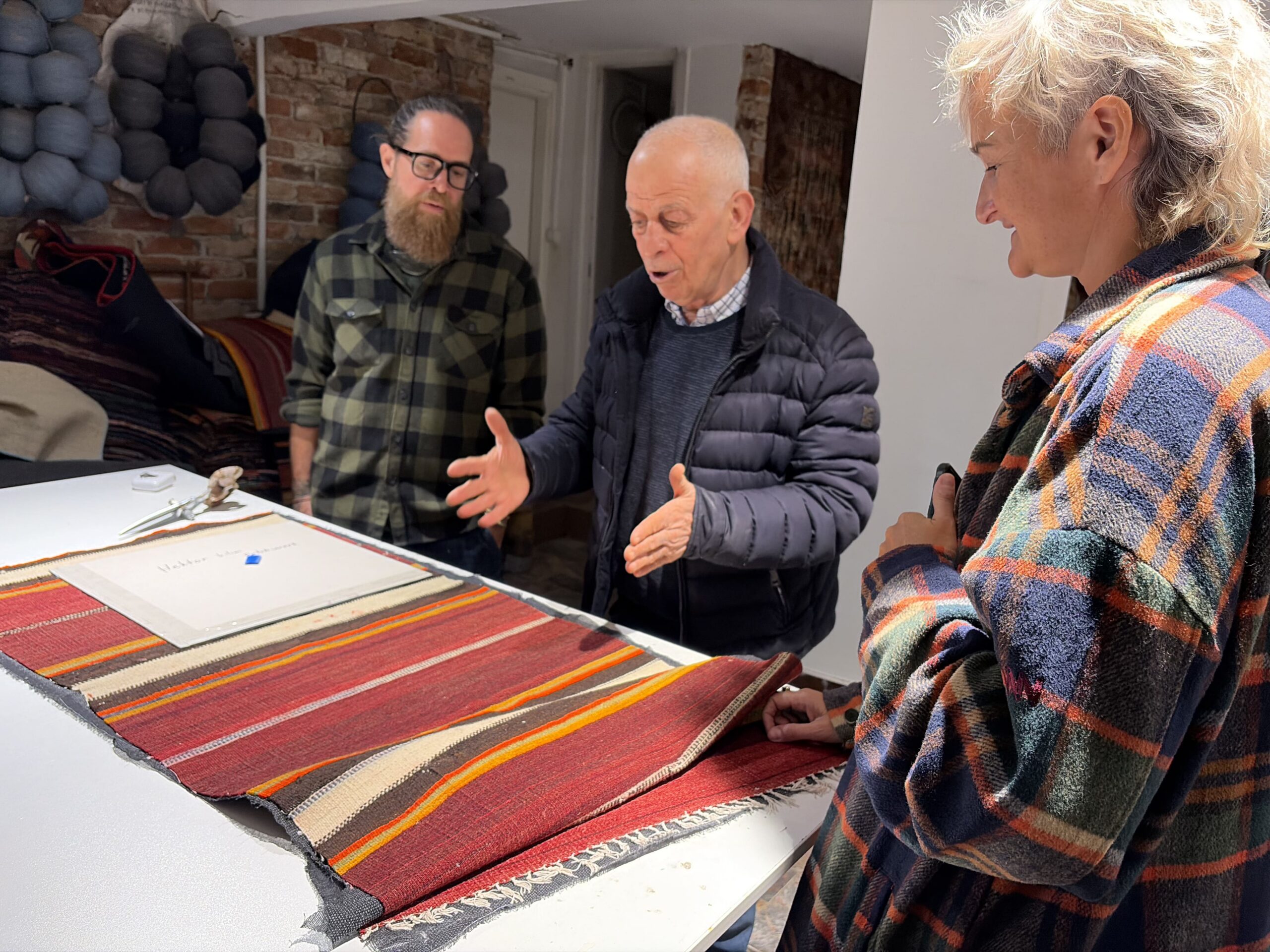 Ahmet Diler demonstrating the weaving structure and craftsmanship of a traditional Turkish kilim during a guided workshop at Kirkit Rugs in Istanbul.