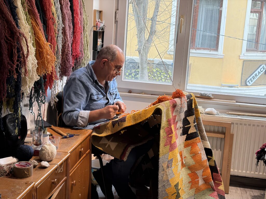 Master weaver handcrafting a traditional Turkish kilim using centuries-old weaving techniques at the Kirkit Rugs workshop in Istanbul.