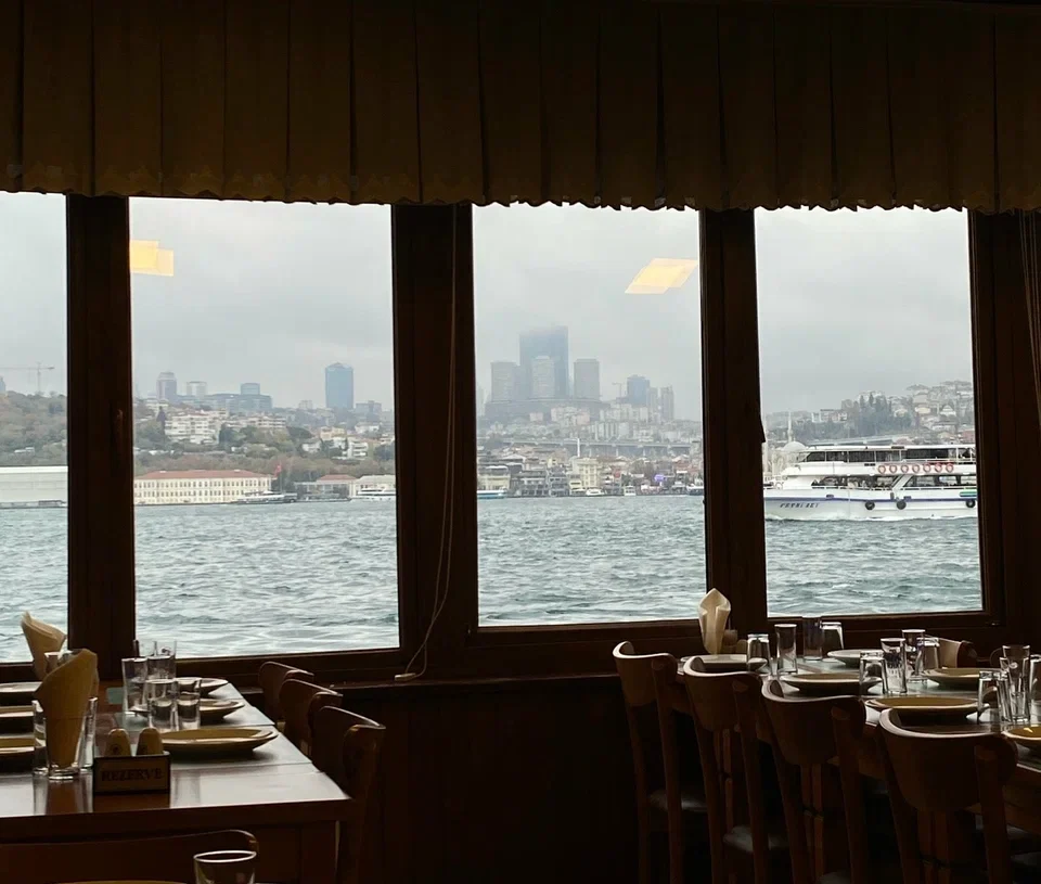 Dining room overlooking the Bosphorus with panoramic views of the Istanbul skyline and boats crossing the strait