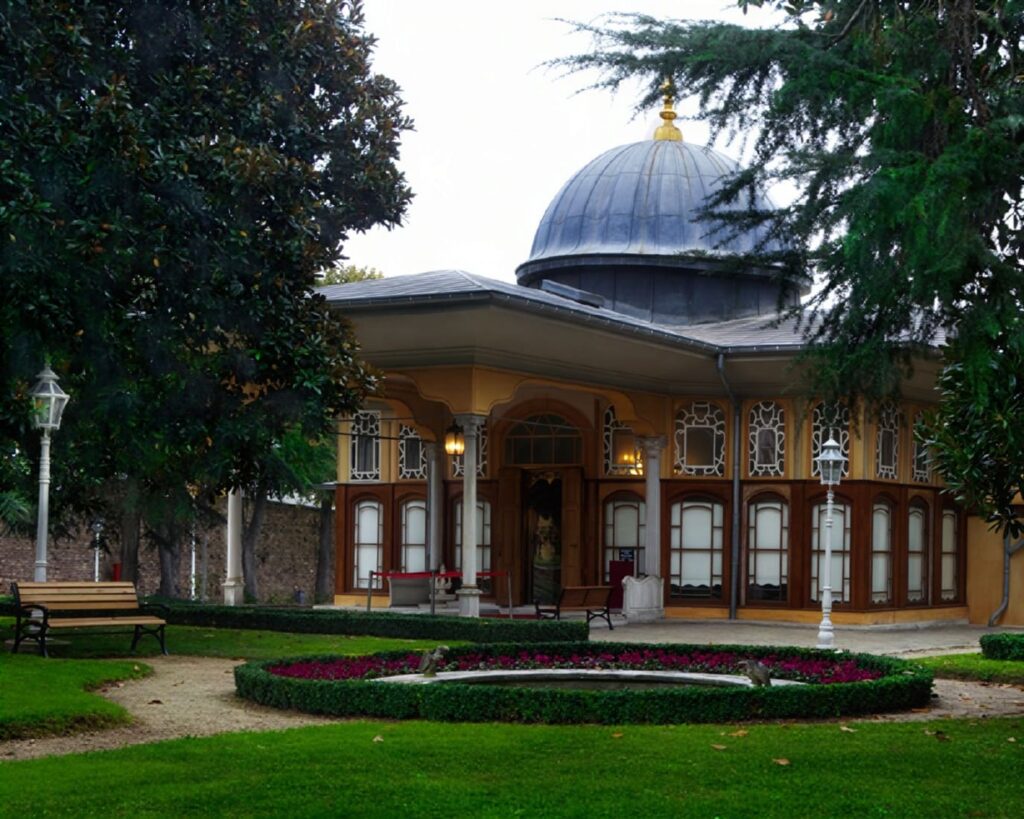Aynalıkavak Kasrı Ottoman garden pavilion in Hasköy, Istanbul, with its lead dome and gold finial set behind a formal circular flower bed in the manicured grounds