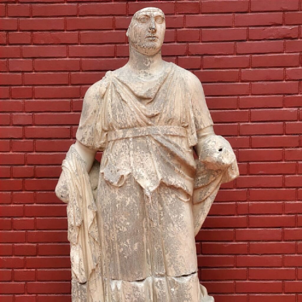Marble statue of Dionysus from the Fountain of Trajan on Curetes Street, displayed at the Ephesus Archaeological Museum in Selçuk, wearing layered chiton and himation and holding a round patera