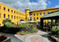 Four Seasons Hotel Istanbul at Sultanahmet's former prison courtyard with the watchtower, garden plantings and the glass-enclosed Avlu restaurant entrance