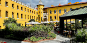 Four Seasons Hotel Istanbul at Sultanahmet's former prison courtyard with the watchtower, garden plantings and the glass-enclosed Avlu restaurant entrance