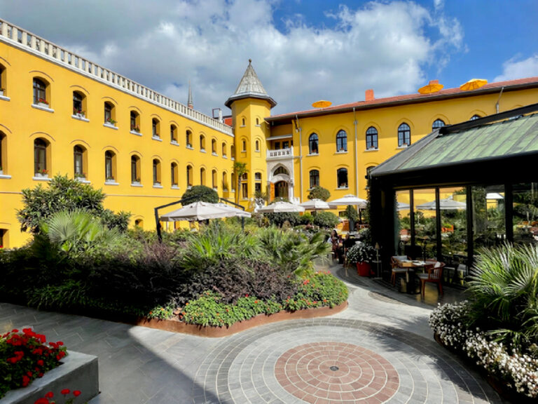 Four Seasons Hotel Istanbul at Sultanahmet's former prison courtyard with the watchtower, garden plantings and the glass-enclosed Avlu restaurant entrance
