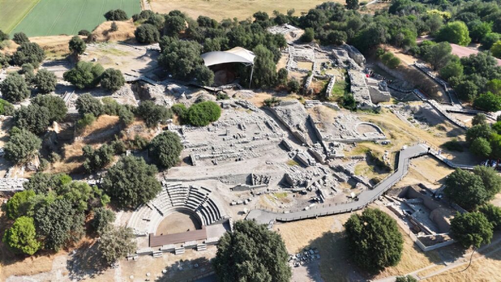 Aerial view of the Hisarlık archaeological site showing the ancient theatre and excavation trenches