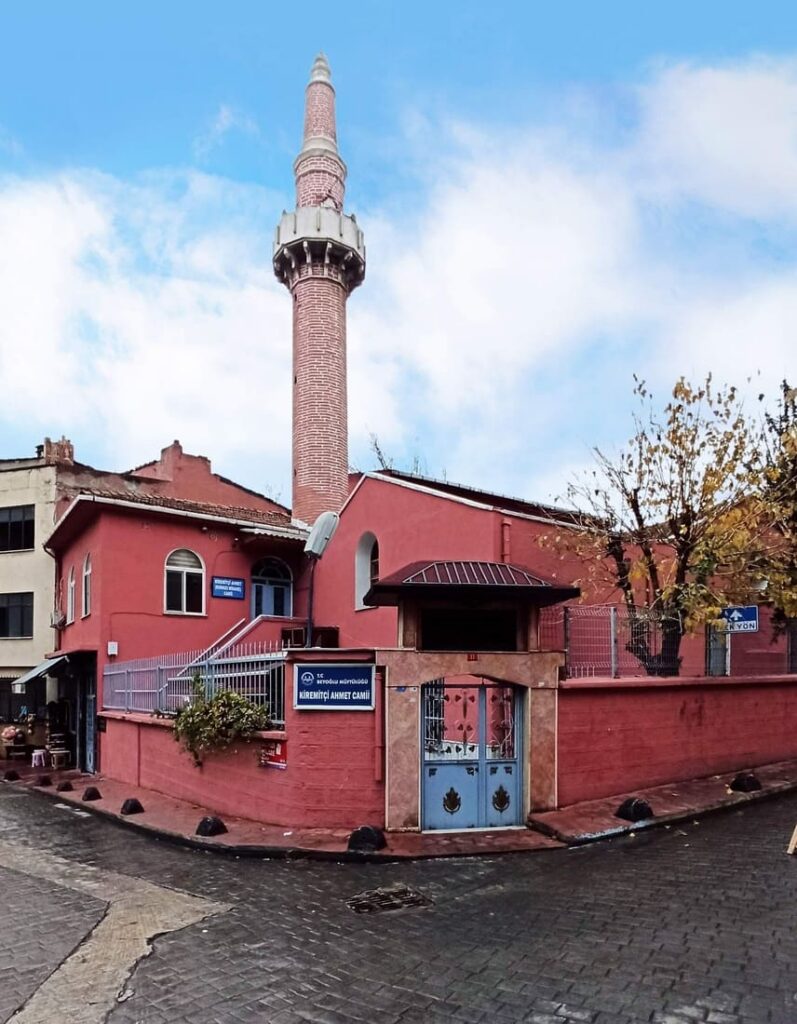 Kiremitçi Ahmet Camii — the Red Minaret Mosque — in Hasköy, Istanbul: a terracotta-red rendered building with a slender red brick minaret, the landmark that gives Kırmızı Minare Street its name, against a blue winter sky