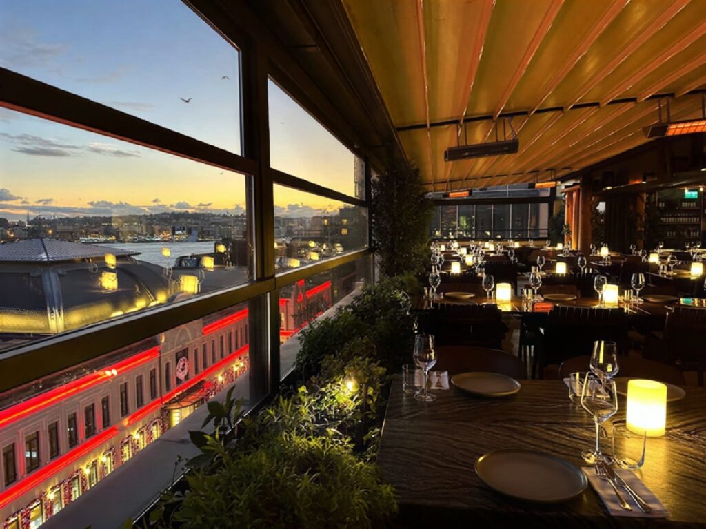 Candlelit dining room at Manifest Roof Restaurant overlooking the Golden Horn at dusk