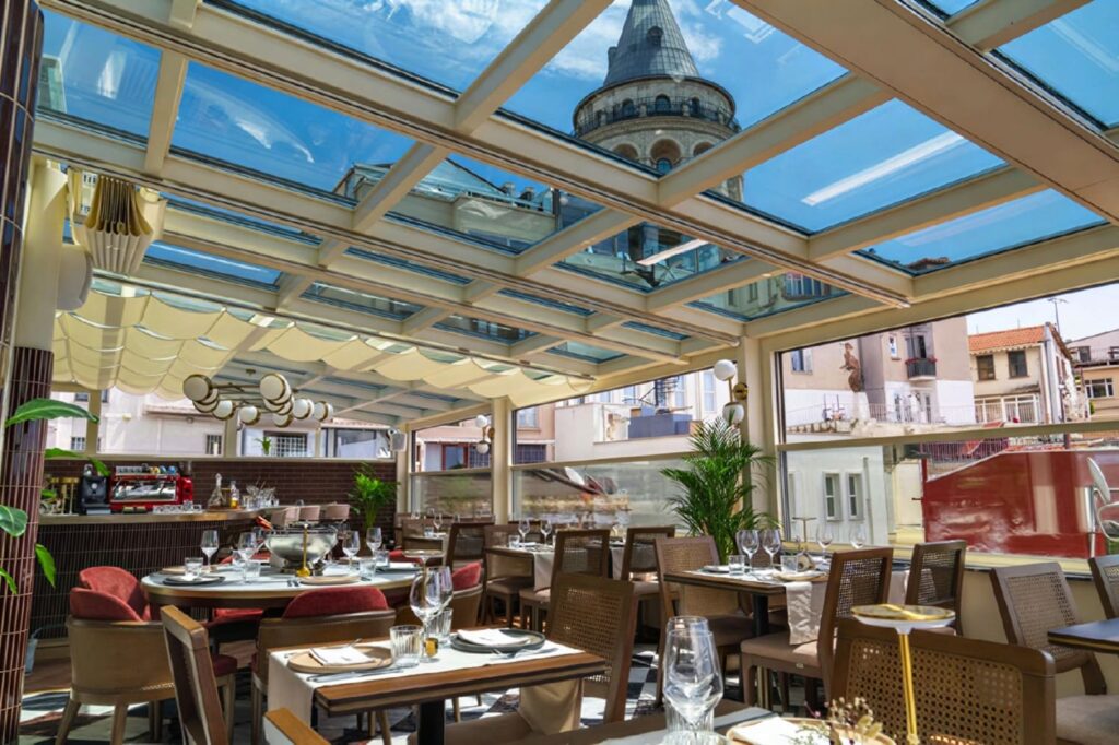 Glass panel skylight at Manifest Roof Restaurant with Galata Tower reflected and framed directly above