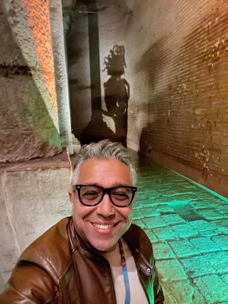 Orçun Kamit smiling inside the Basilica Cistern in Istanbul.