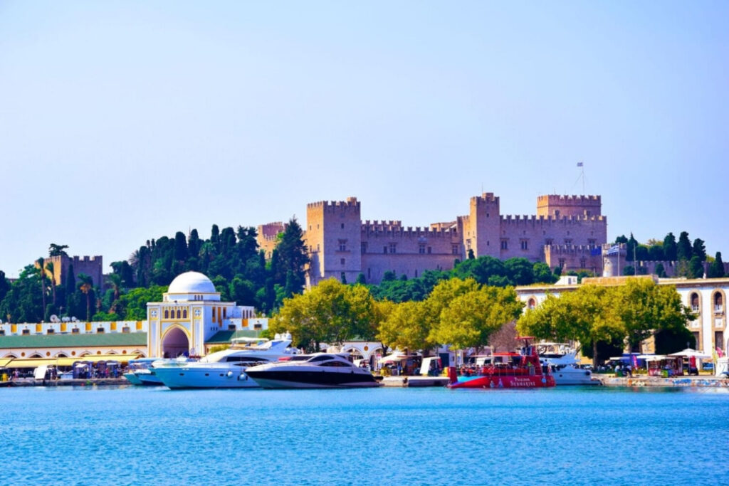The Palace of the Grand Master of the Knights of Rhodes rising above the medieval harbour, visible from the sea as the ferry from Marmaris approaches — built by the same Hospitaller crusaders who constructed Bodrum castle across the strait