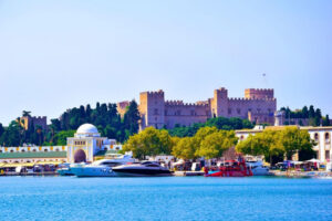 The Palace of the Grand Master of the Knights of Rhodes rising above the medieval harbour, visible from the sea as the ferry from Marmaris approaches — built by the same Hospitaller crusaders who constructed Bodrum castle across the strait