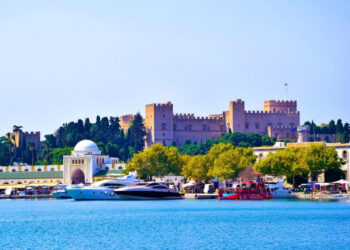 The Palace of the Grand Master of the Knights of Rhodes rising above the medieval harbour, visible from the sea as the ferry from Marmaris approaches — built by the same Hospitaller crusaders who constructed Bodrum castle across the strait