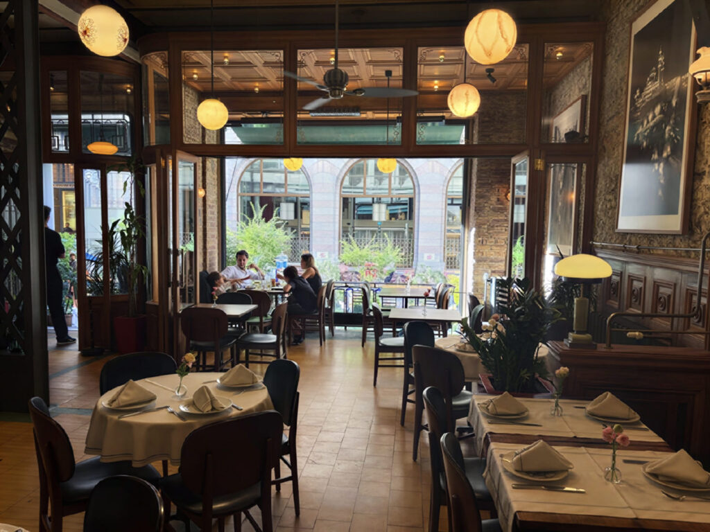 Salon Galata dining room with open folding glass doors to Bankalar Caddesi — white tablecloths and globe lights, Karaköy