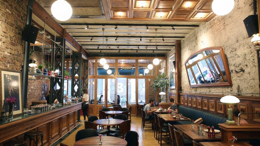Salon Galata interior dining room — exposed brick walls, dark wood bar and globe pendant lights at Bozkurt Han, Karaköy