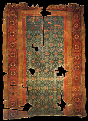 Fragment of a 13th-century Anatolian Seljuk rug from Konya, preserving geometric patterns despite centuries of wear.