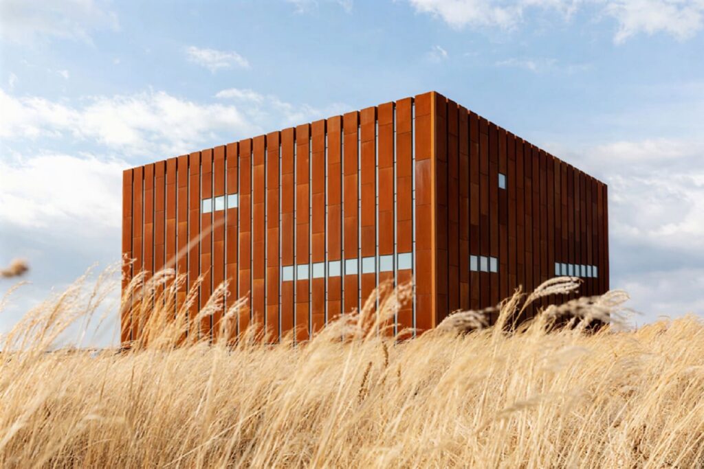 Troy Museum's corten steel cube rising above a golden wheat field near Çanakkale