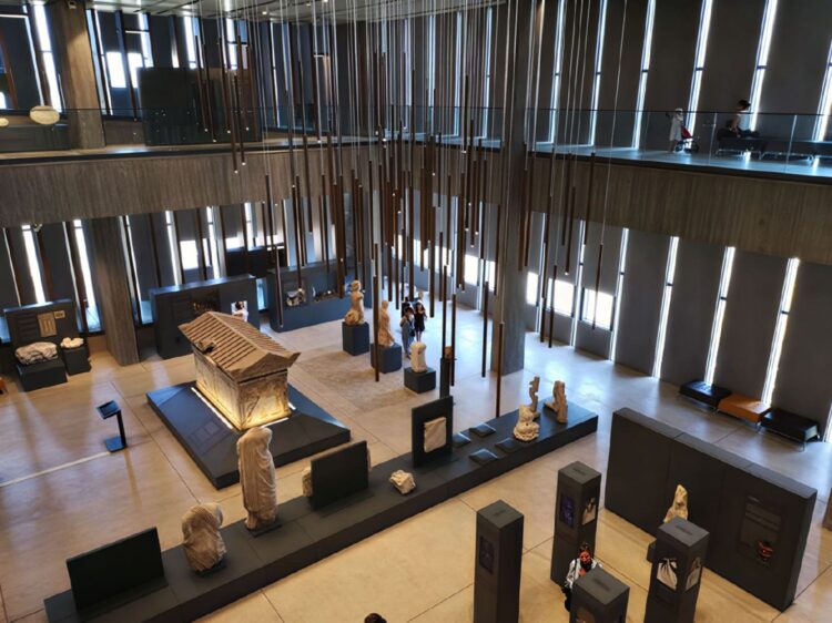 Elevated view of the Troy Museum's main gallery atrium with statues and a marble sarcophagus