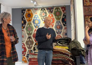 Visitors exploring traditional Anatolian kilims at Kirkit Rugs in Sultanahmet, Istanbul, surrounded by handcrafted Turkish flatweaves and symbolic woven motifs.