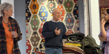 Visitors exploring traditional Anatolian kilims at Kirkit Rugs in Sultanahmet, Istanbul, surrounded by handcrafted Turkish flatweaves and symbolic woven motifs.