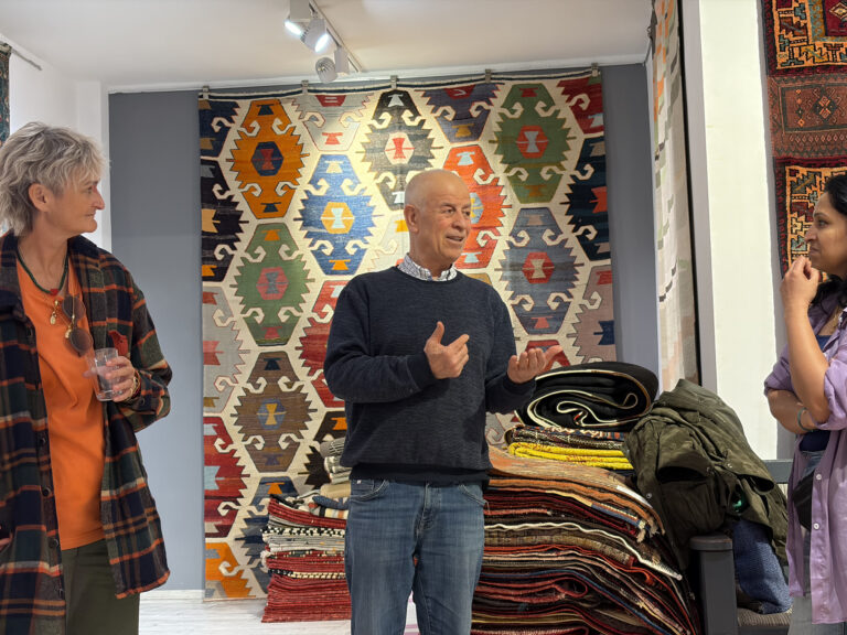 Visitors exploring traditional Anatolian kilims at Kirkit Rugs in Sultanahmet, Istanbul, surrounded by handcrafted Turkish flatweaves and symbolic woven motifs.