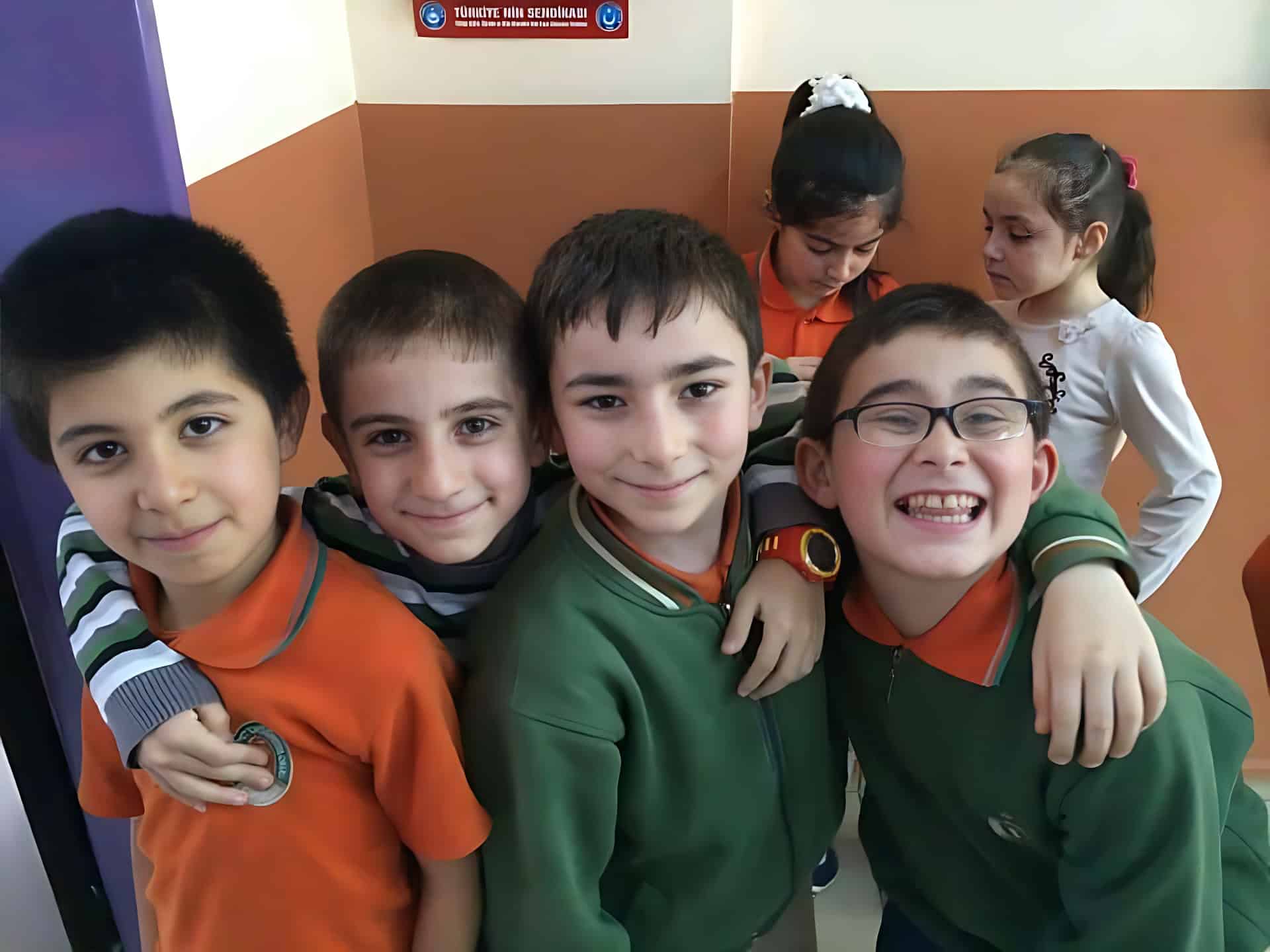 Pupils in uniform crowding round the camera during a school visit
